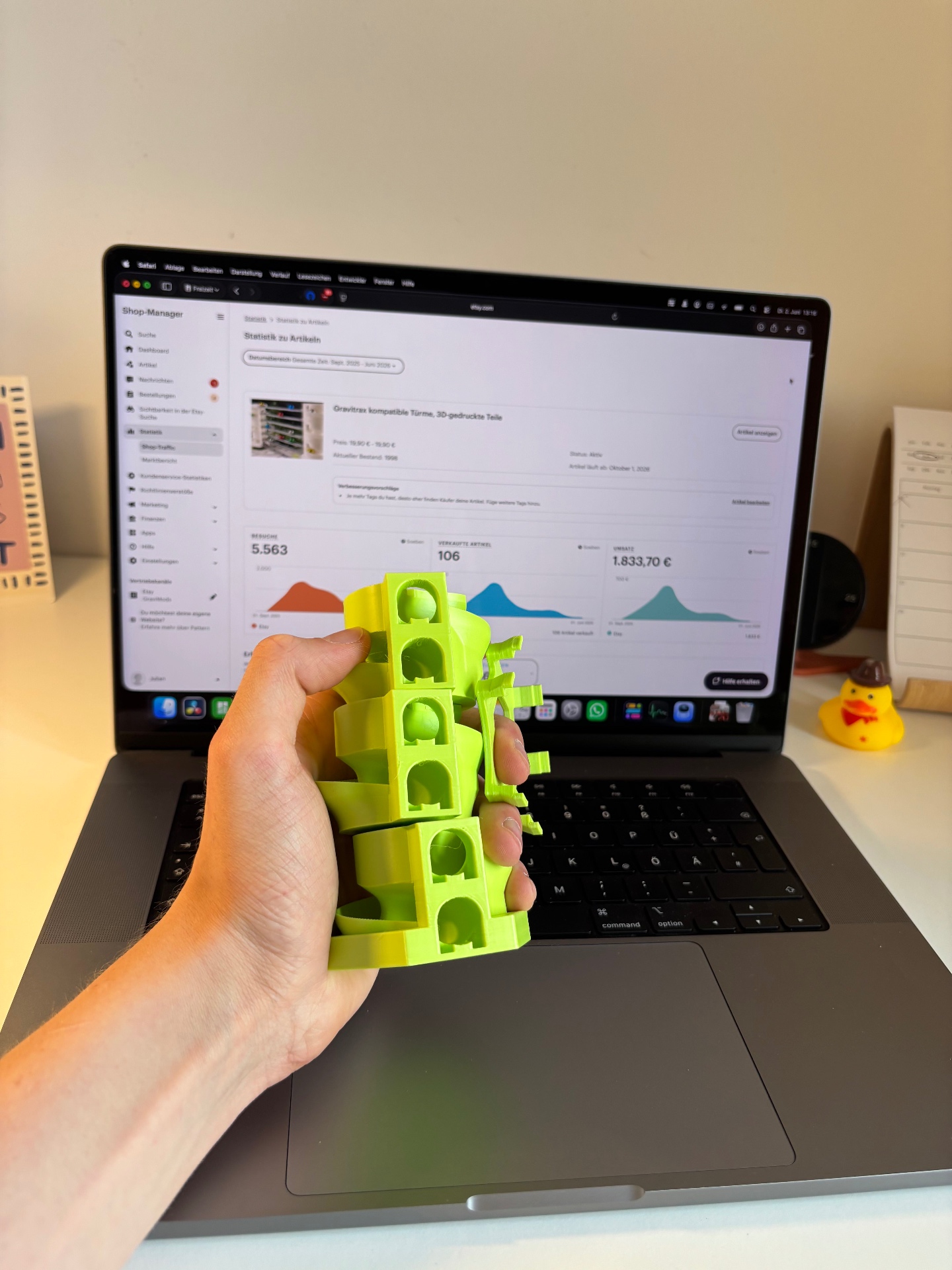 Etsy Dashboard auf einem Laptop und ein 3D-gedrucktes Teil in der Hand